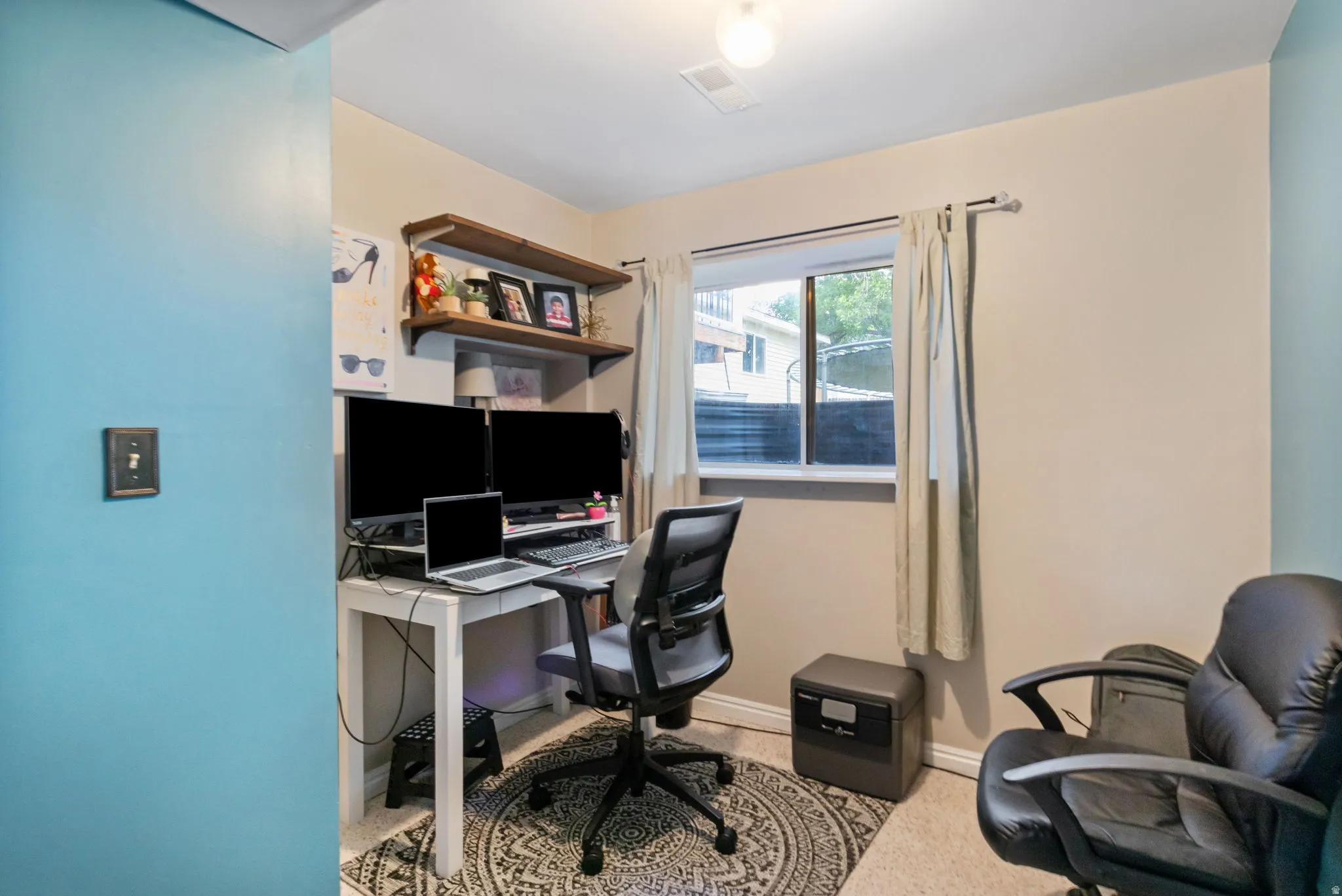 Room featuring a window with exterior views, wall-mounted shelving, and neutral wall tones