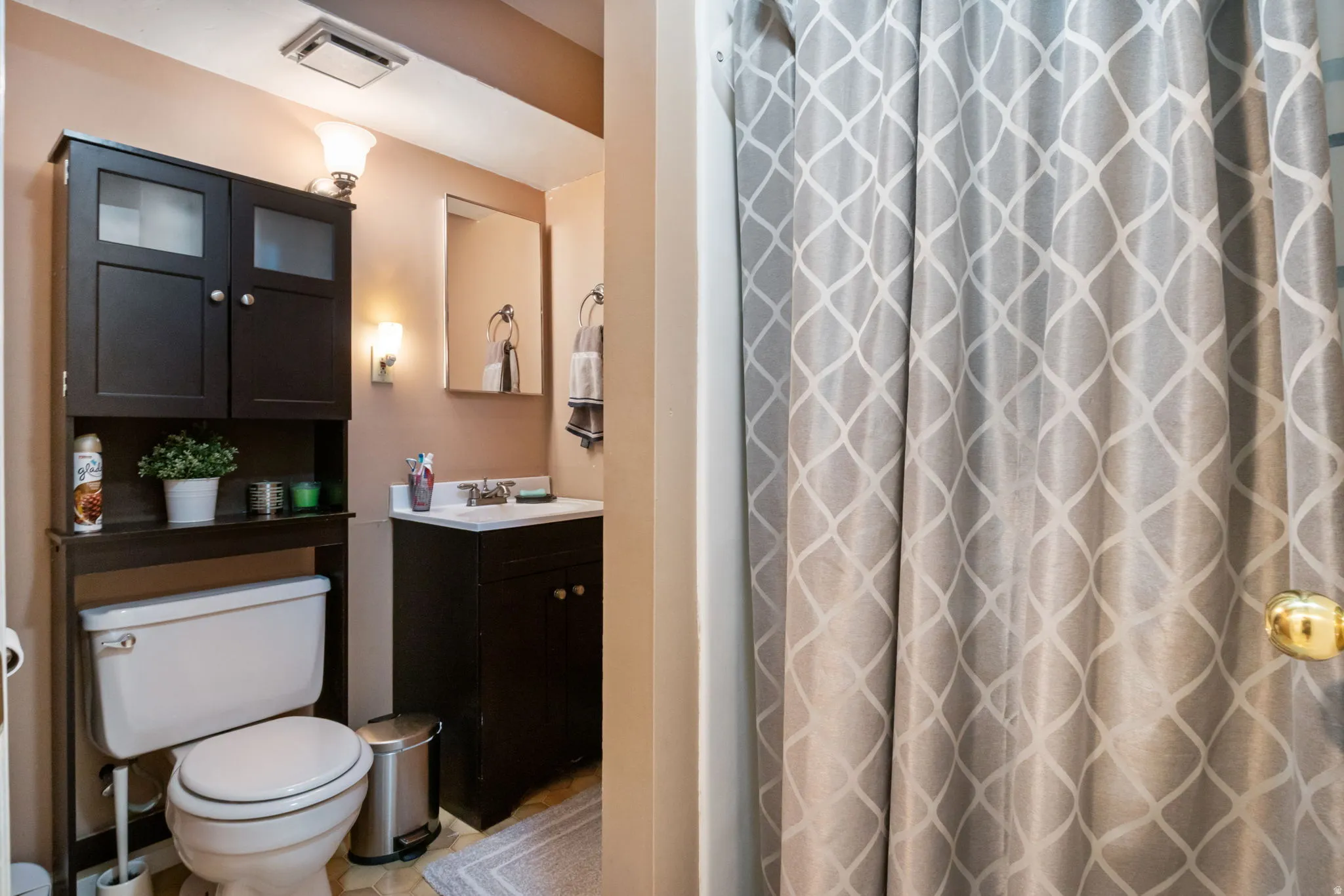 Full bathroom featuring a dark wood-finish vanity with a white countertop and a wall-mounted mirror