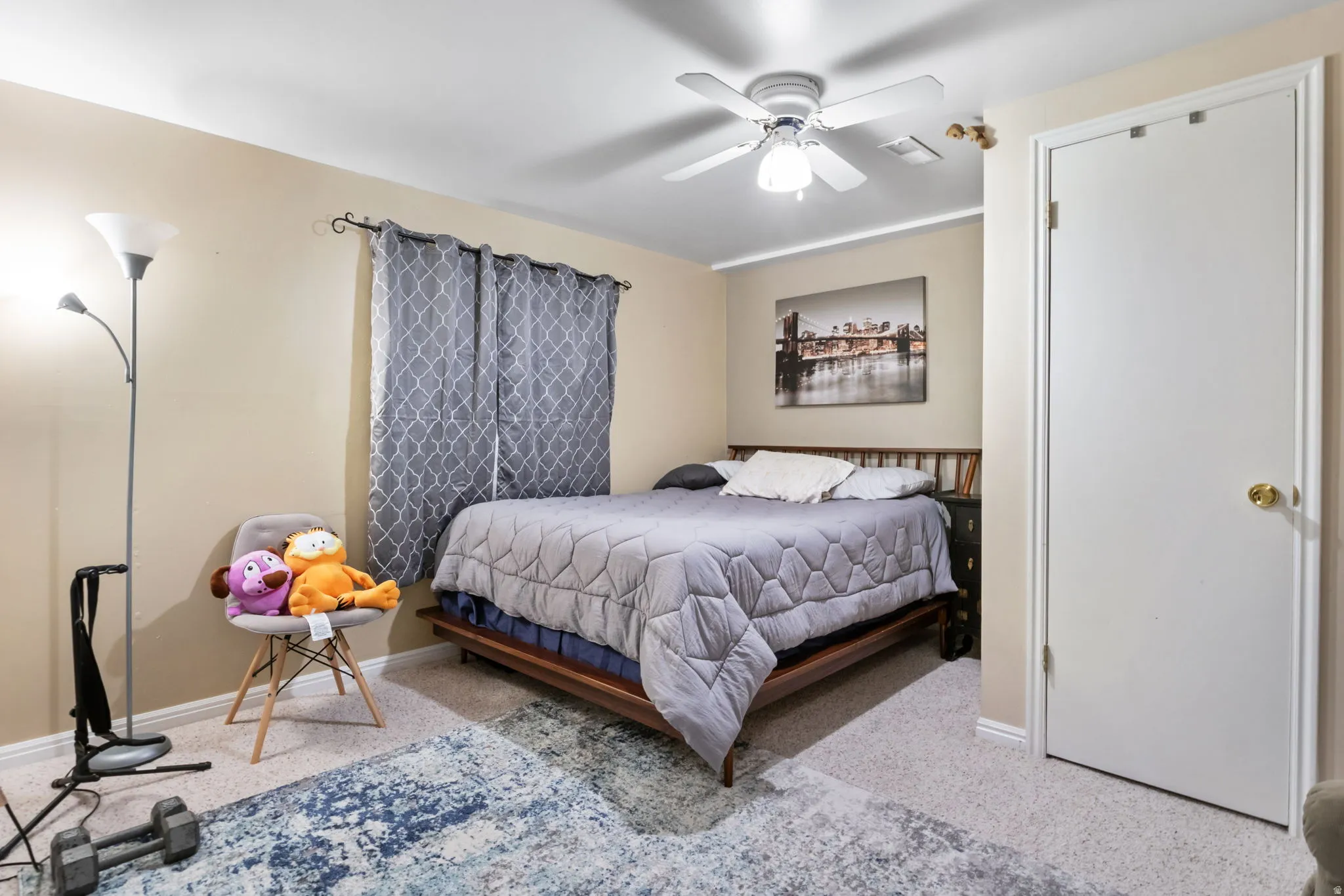 Carpeted bedroom with a ceiling fan