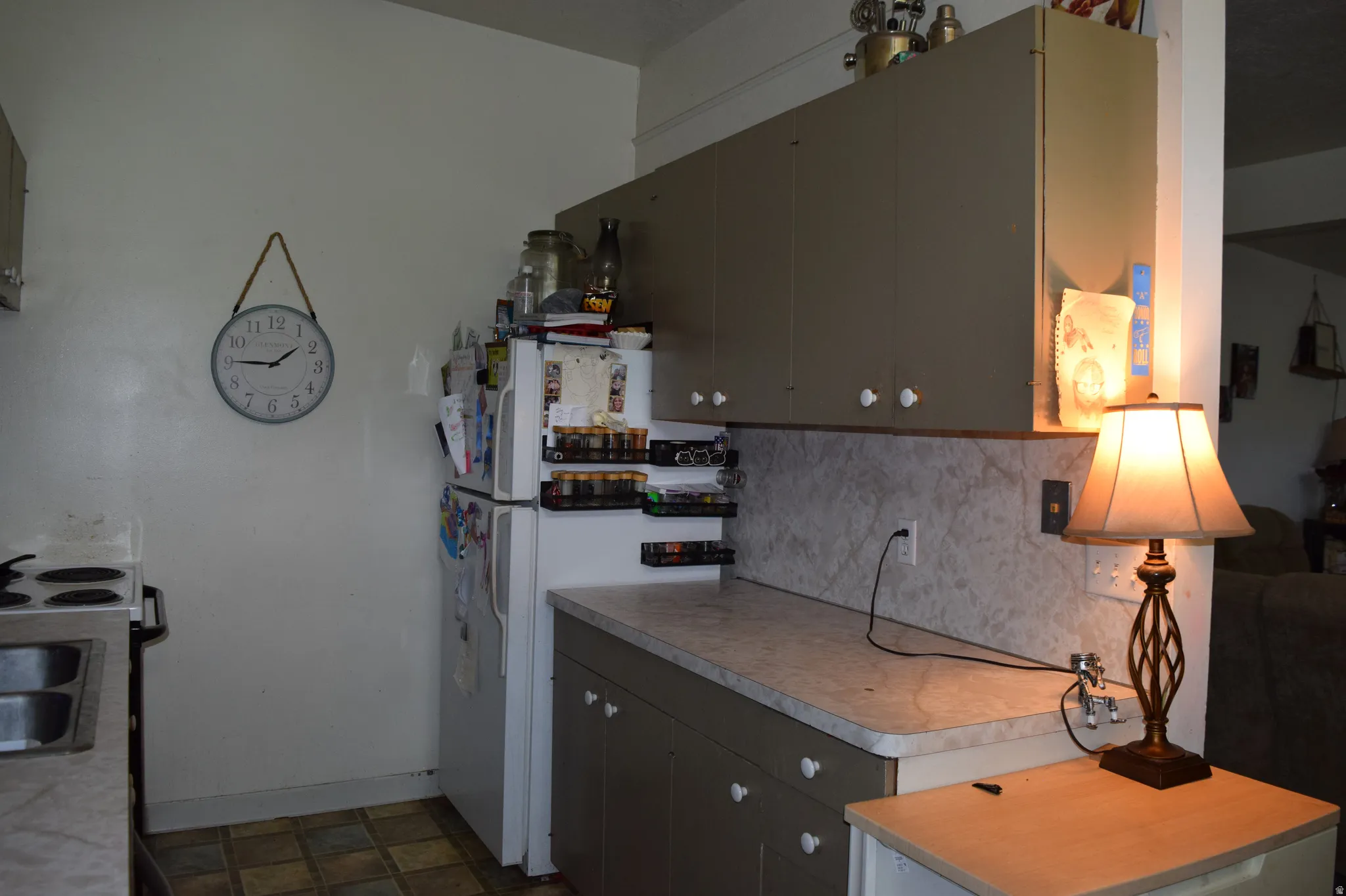Kitchen featuring neutral-toned cabinetry, laminate countertops, and a white appliance package
