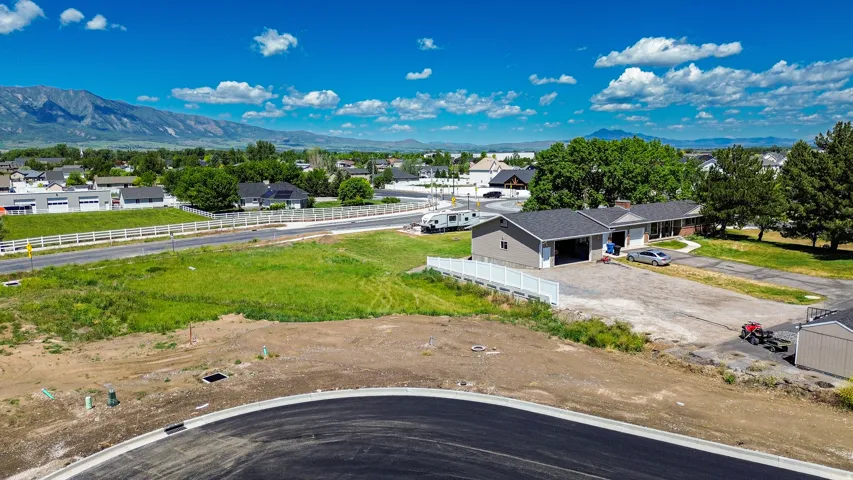 Expansive property featuring a single-story residence with an attached two-car garage, an additional detached garage, and a large gravel driveway