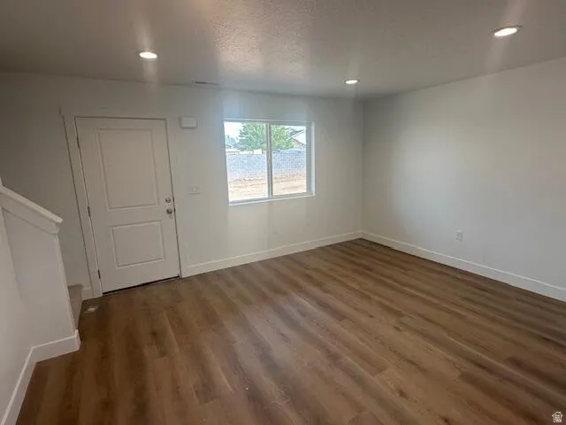Open concept space featuring wood-finish flooring, recessed lighting, and white baseboards