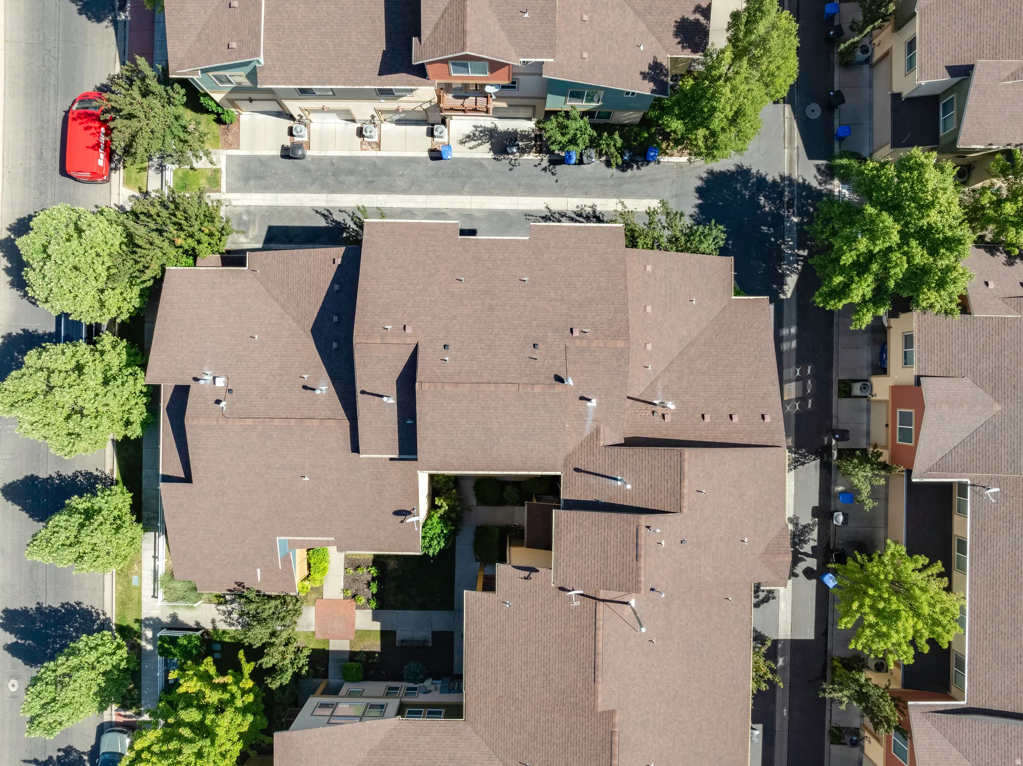 Aerial perspective showcasing a residential complex with multiple brown-shingled rooftops