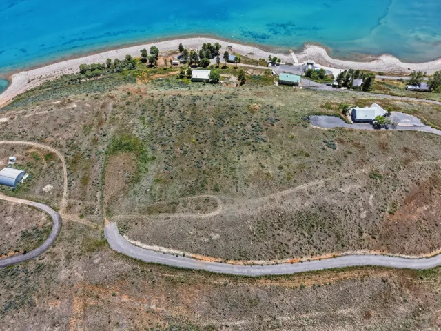 Aerial perspective showcasing extensive undeveloped land with a winding paved road