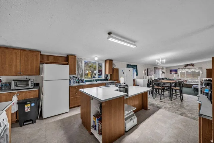Kitchen featuring wood cabinetry, light-toned countertops, and a window above the sink