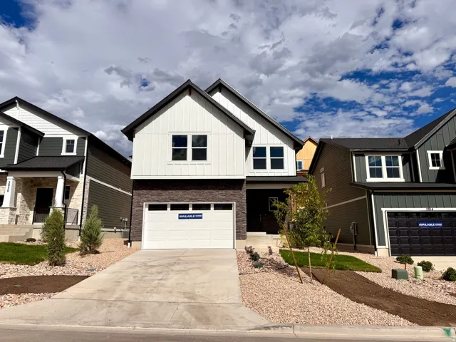 Contemporary exterior with vertical white siding, dark brick lower facade, attached two-car garage, and a concrete driveway