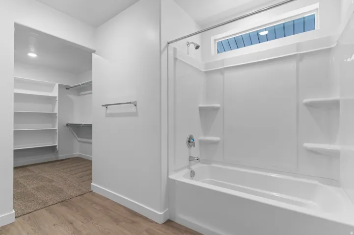 White tub and shower combination with a transom window