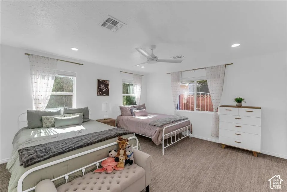 Bright room featuring white walls and textured carpet flooring