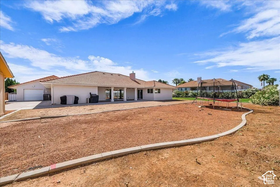 Spacious backyard area featuring a concrete border and a large patio with columns