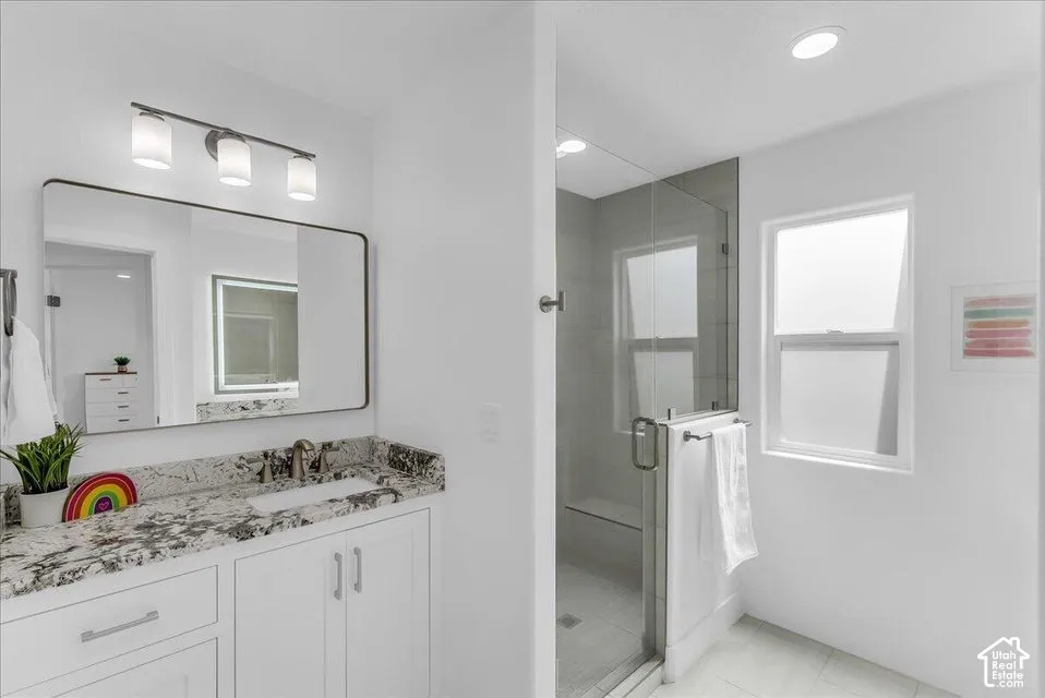Bathroom featuring a white vanity with a dark speckled countertop, undermount sink, and brushed nickel faucet