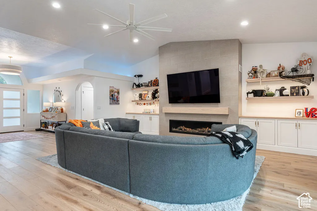 Living area featuring light wood-finish flooring, a contemporary ceiling fan, and recessed lighting