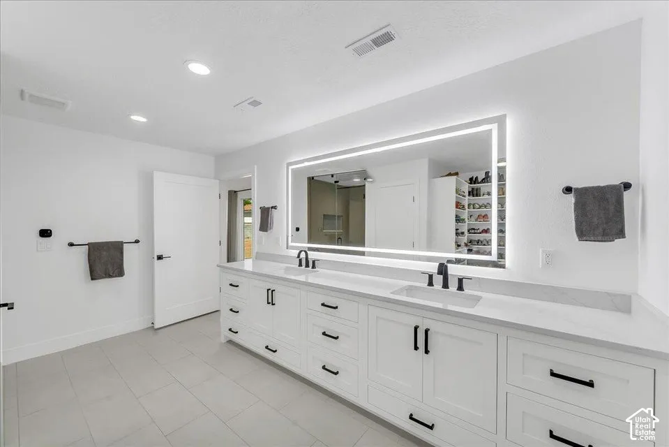 Double vanity with white shaker cabinetry, quartz countertops, and matte black fixtures