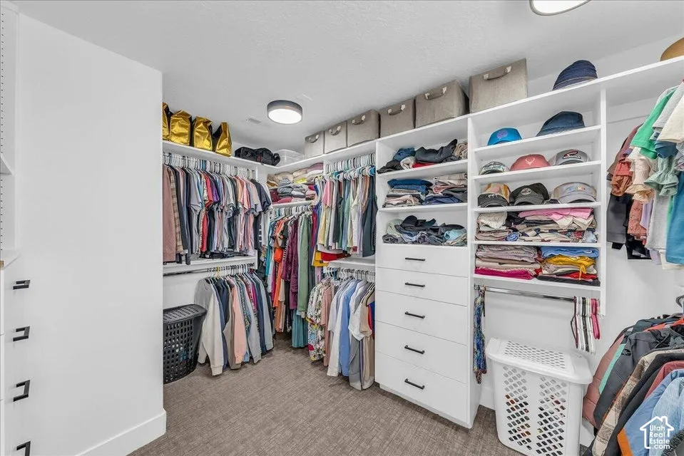 Custom closet system featuring multiple hanging rods, integrated shelving, built-in drawers with modern hardware, and recessed lighting