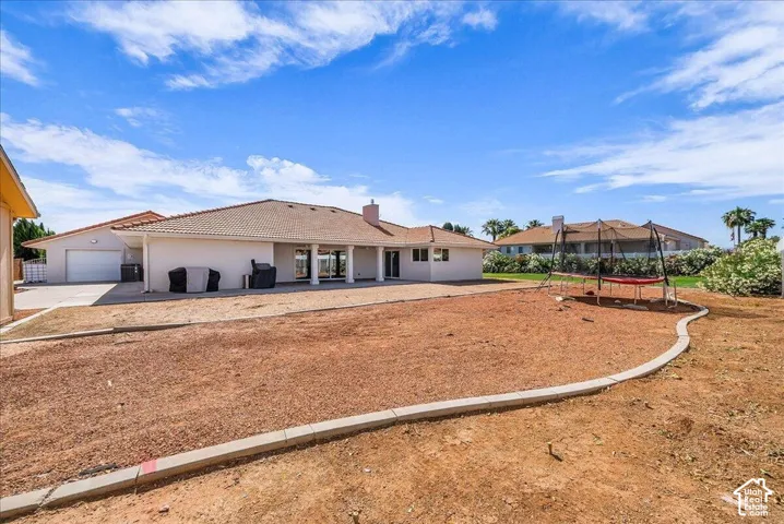 Spacious backyard area featuring a concrete border and a large patio with columns