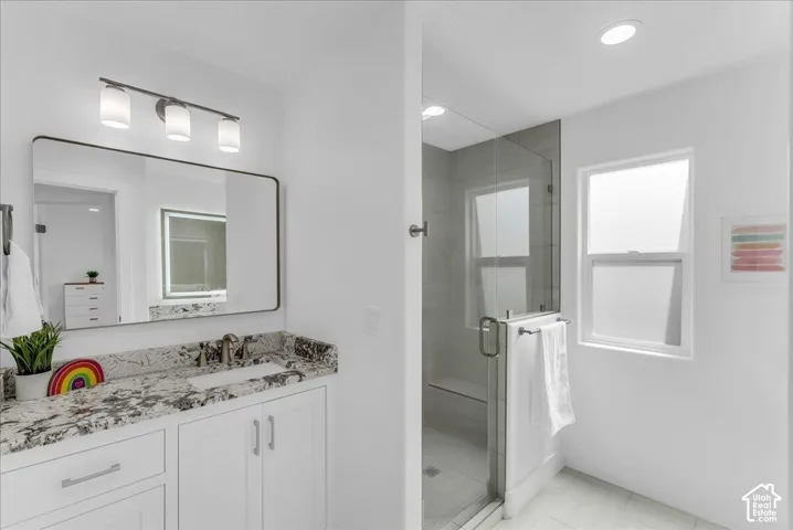 Bathroom featuring a white vanity with a dark speckled countertop, undermount sink, and brushed nickel faucet