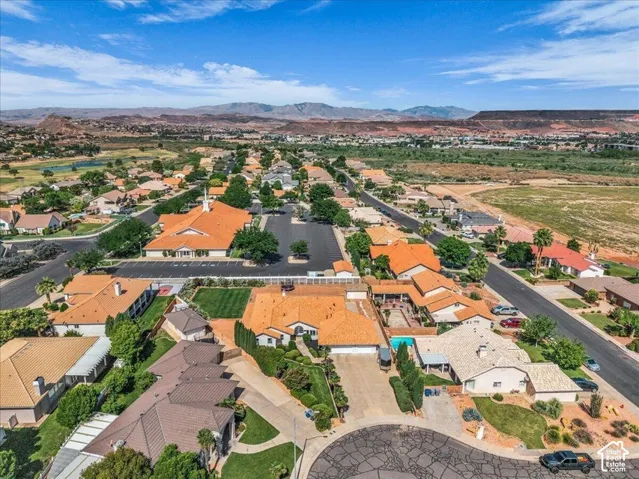 Aerial perspective highlighting residential properties with red rock mountain terrain in the background