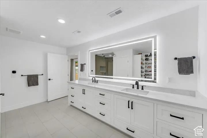 Double vanity with white shaker cabinetry, quartz countertops, and matte black fixtures