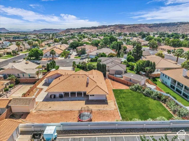 Aerial perspective showcasing a residential property with a tile roof and a spacious backyard