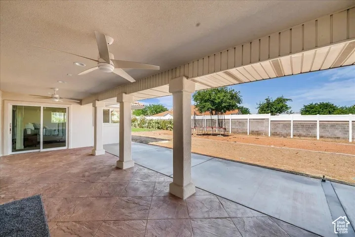 Expansive covered patio featuring stamped concrete flooring, multiple ceiling fans, recessed lighting, and a sliding glass door entry