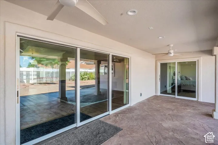 Spacious patio featuring stamped concrete flooring, two ceiling fans, recessed lighting, and multiple sliding glass doors