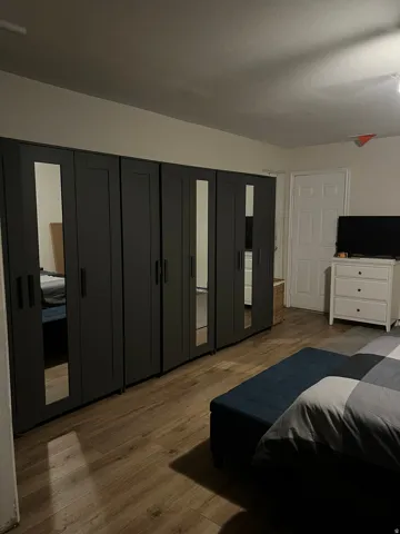 Wall-spanning built-in wardrobe system with mirrored panel doors