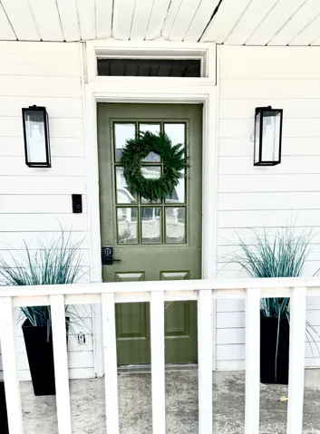 Front entry featuring a paneled door with multiple glass lites, a transom window, and a white paneled exterior