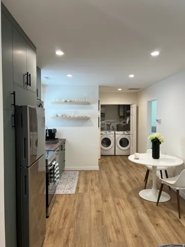 Kitchen area featuring dark green cabinetry, wood-finish flooring, and recessed lighting