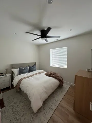 Bedroom featuring wood-finish flooring, a window with blinds, and recessed lighting