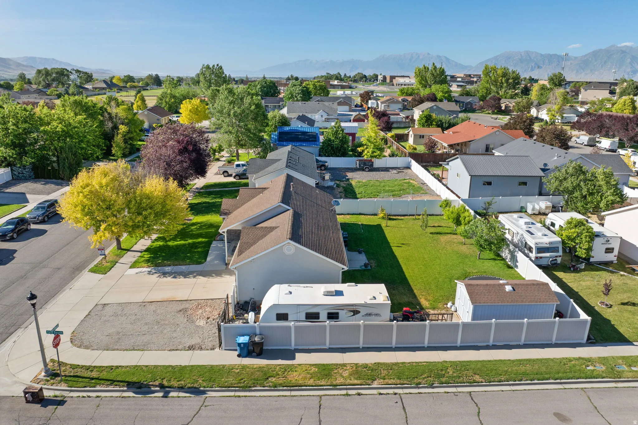 Aerial perspective showcasing a residential property with a detached shed and a gravel side yard