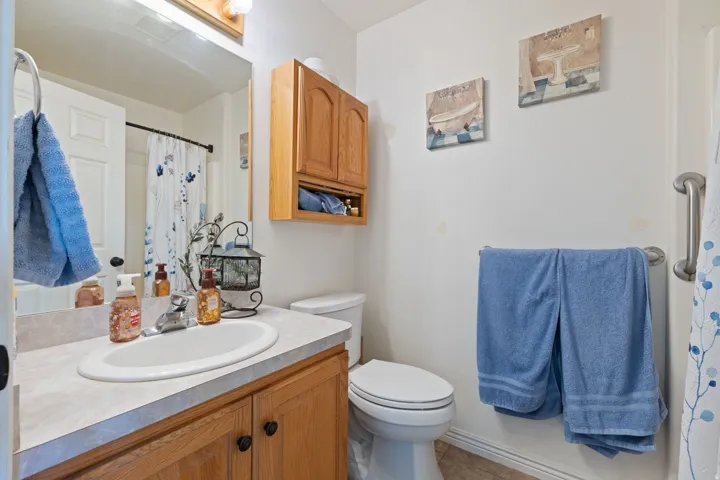 Bathroom vanity with an oval undermount sink, a chrome faucet, and a light-toned countertop