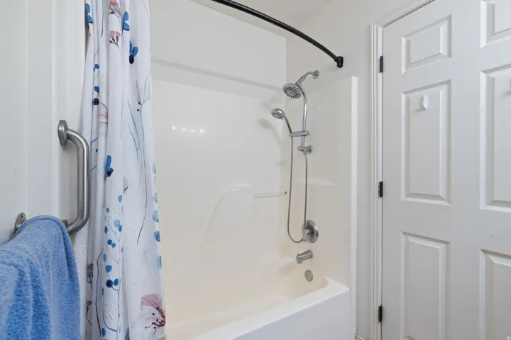 White tub and shower combination with a curved shower rod and a multi-function shower head