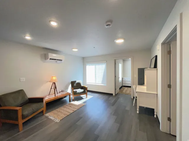 Spacious interior featuring wood-finish flooring, recessed lighting, and a wall-mounted climate control unit