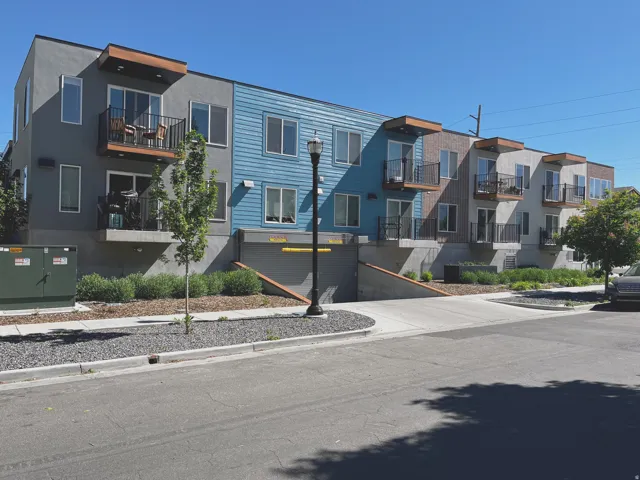 Multi-story residential building with varied facade finishes, including blue siding and stucco