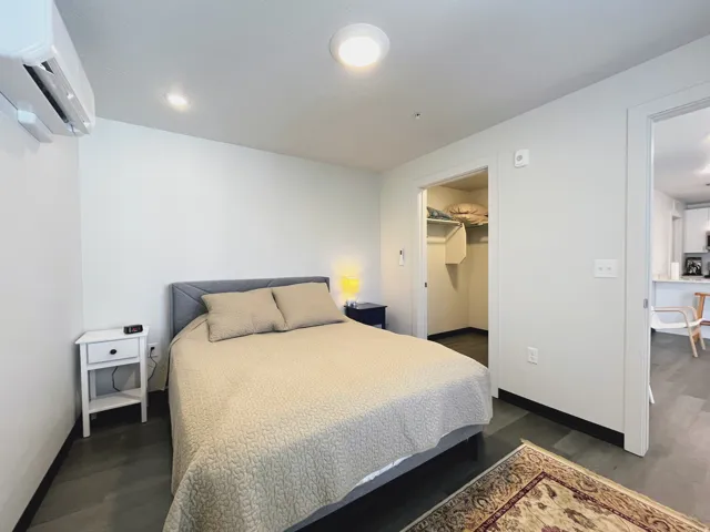 Bedroom featuring dark wood-finish flooring and light gray walls