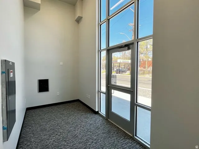 Full-height storefront windows with aluminum framing and a glass entry door