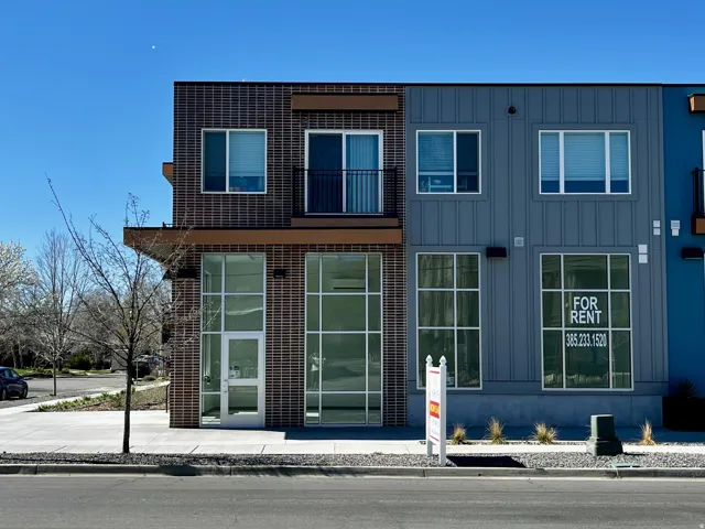Contemporary multi-story building featuring brick and vertical panel siding