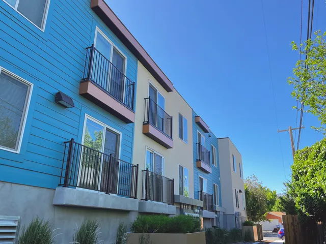 Contemporary multi-story exterior featuring vibrant blue and neutral-toned siding