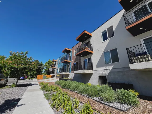 Multi-story building featuring contemporary architecture with light-colored siding and dark accents
