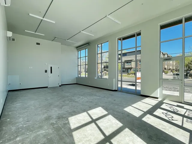 Spacious interior featuring high ceilings, concrete flooring, and multiple large windows