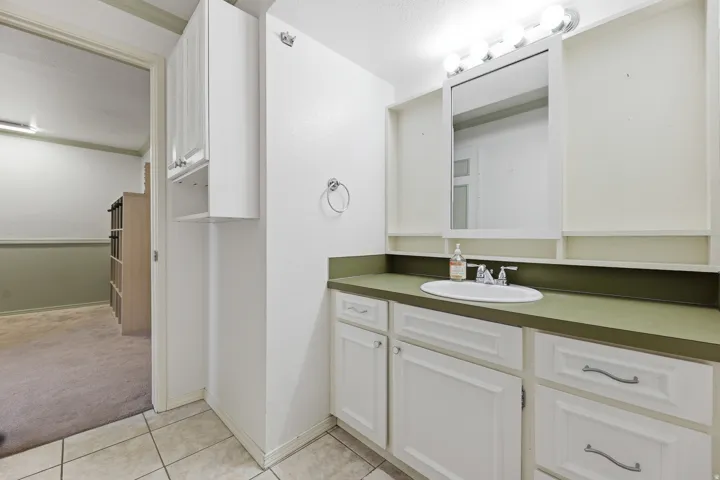 Bathroom vanity featuring a single basin sink, integrated countertop, and ample under-sink storage