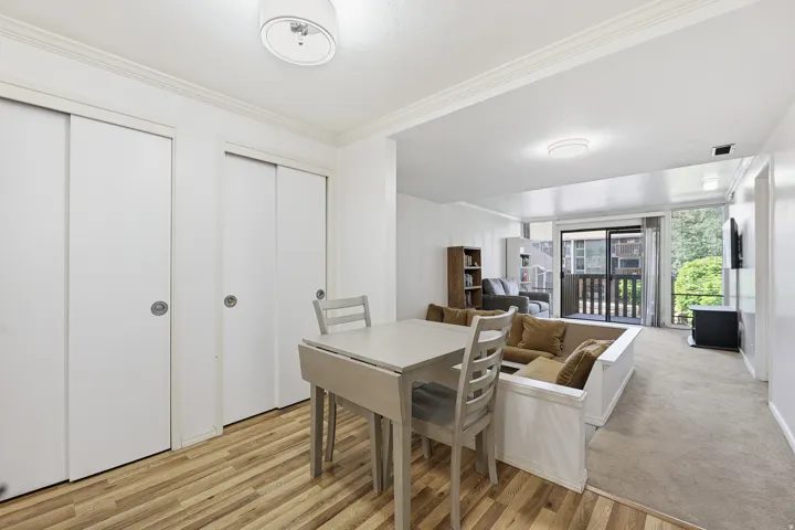 Dining area with wood-finish flooring and two sets of white sliding closet doors
