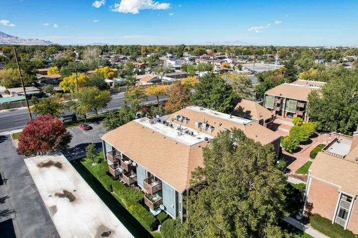 Aerial perspective featuring multi-story residential buildings with tan shingle roofs and private balconies