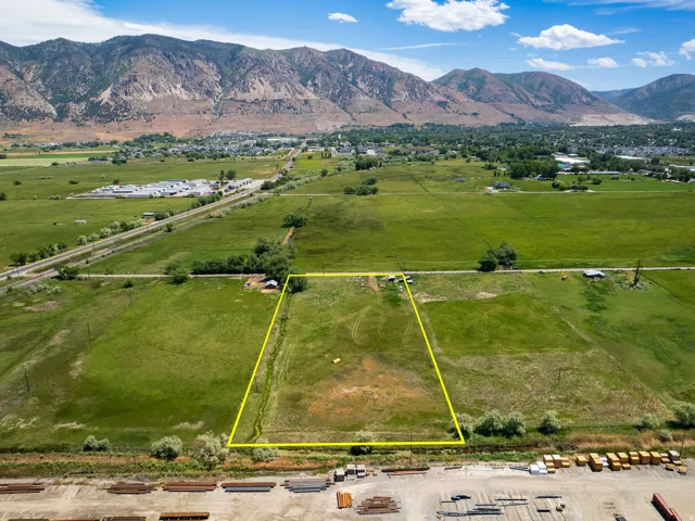 Expansive grass lot featuring a flat topography and distant mountain backdrop