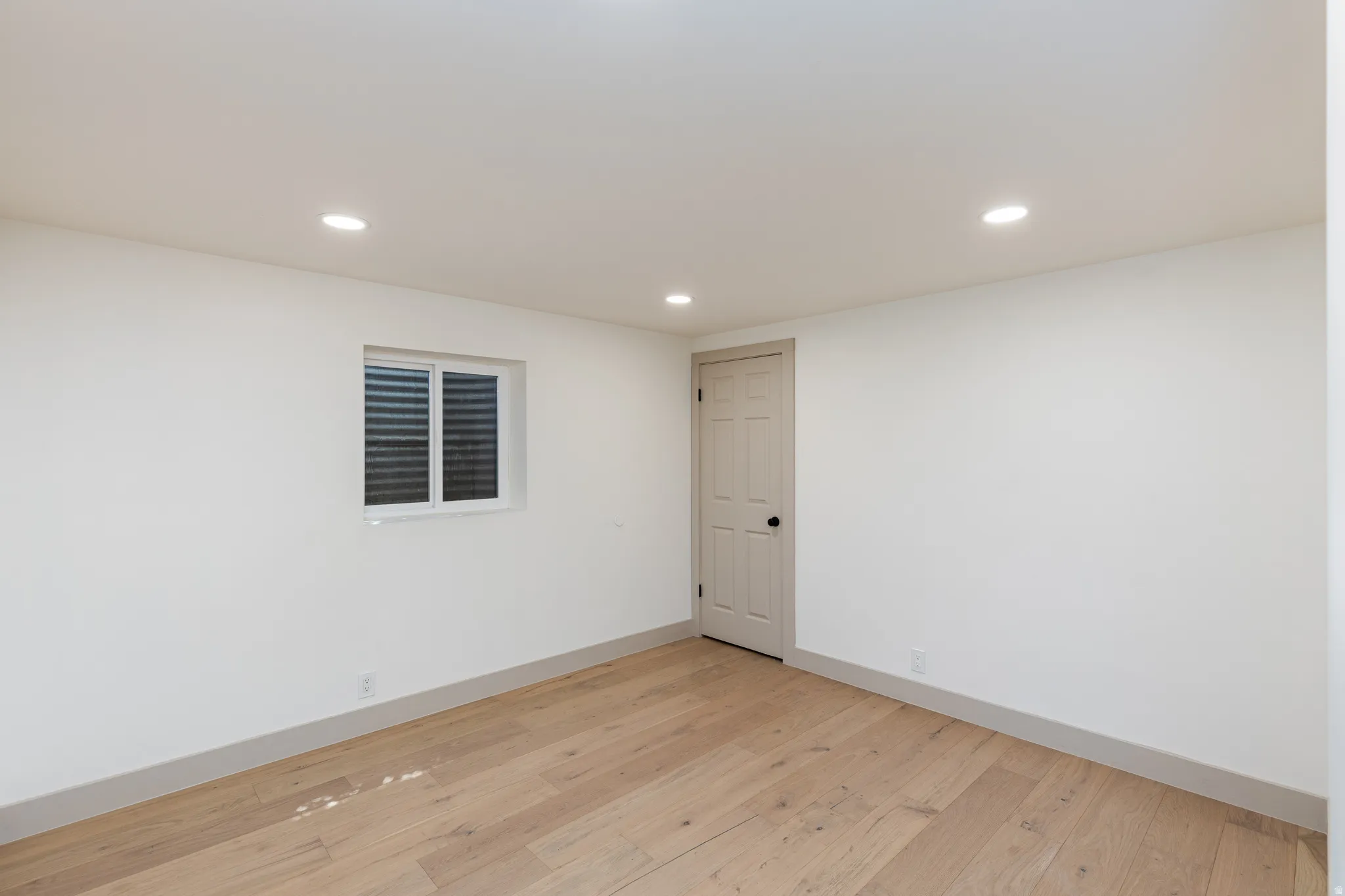 Room featuring light wood-finish flooring, white walls, and recessed ceiling lighting