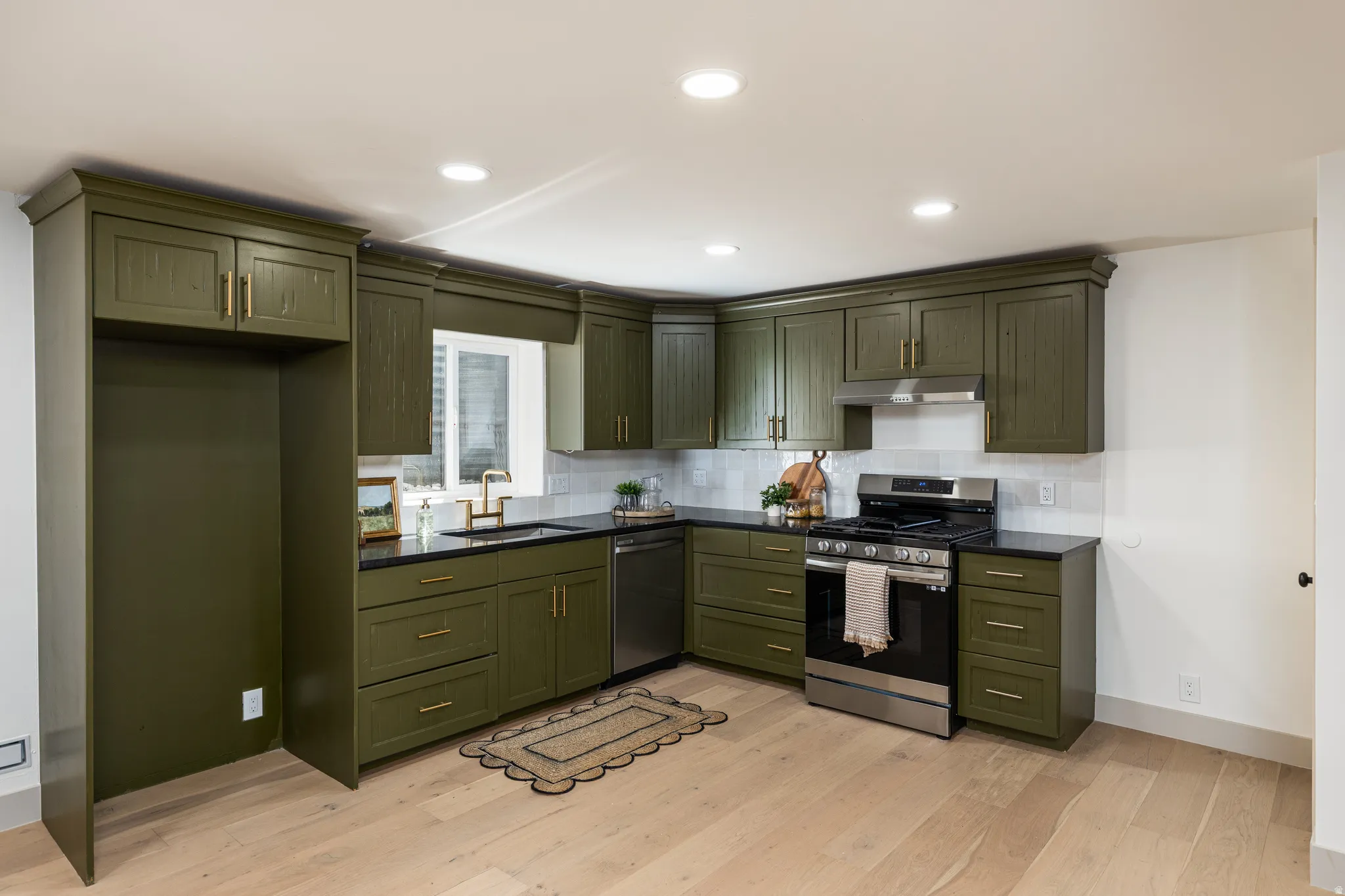 Kitchen featuring abundant olive green cabinetry, dark countertops, a tile backsplash, and recessed lighting