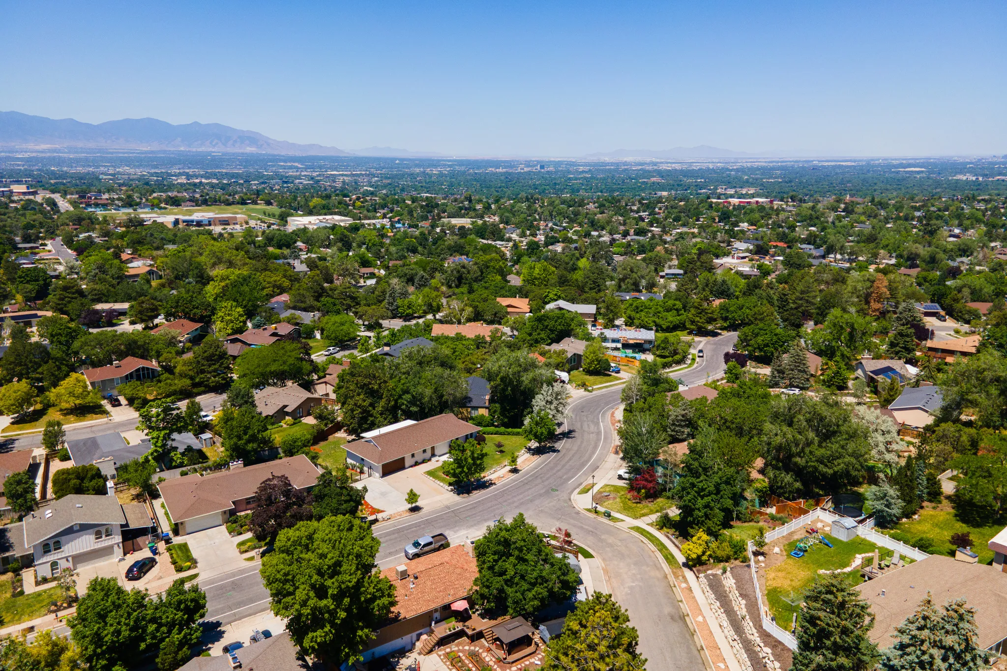 Sprawling residential area with mature tree canopy and winding roads