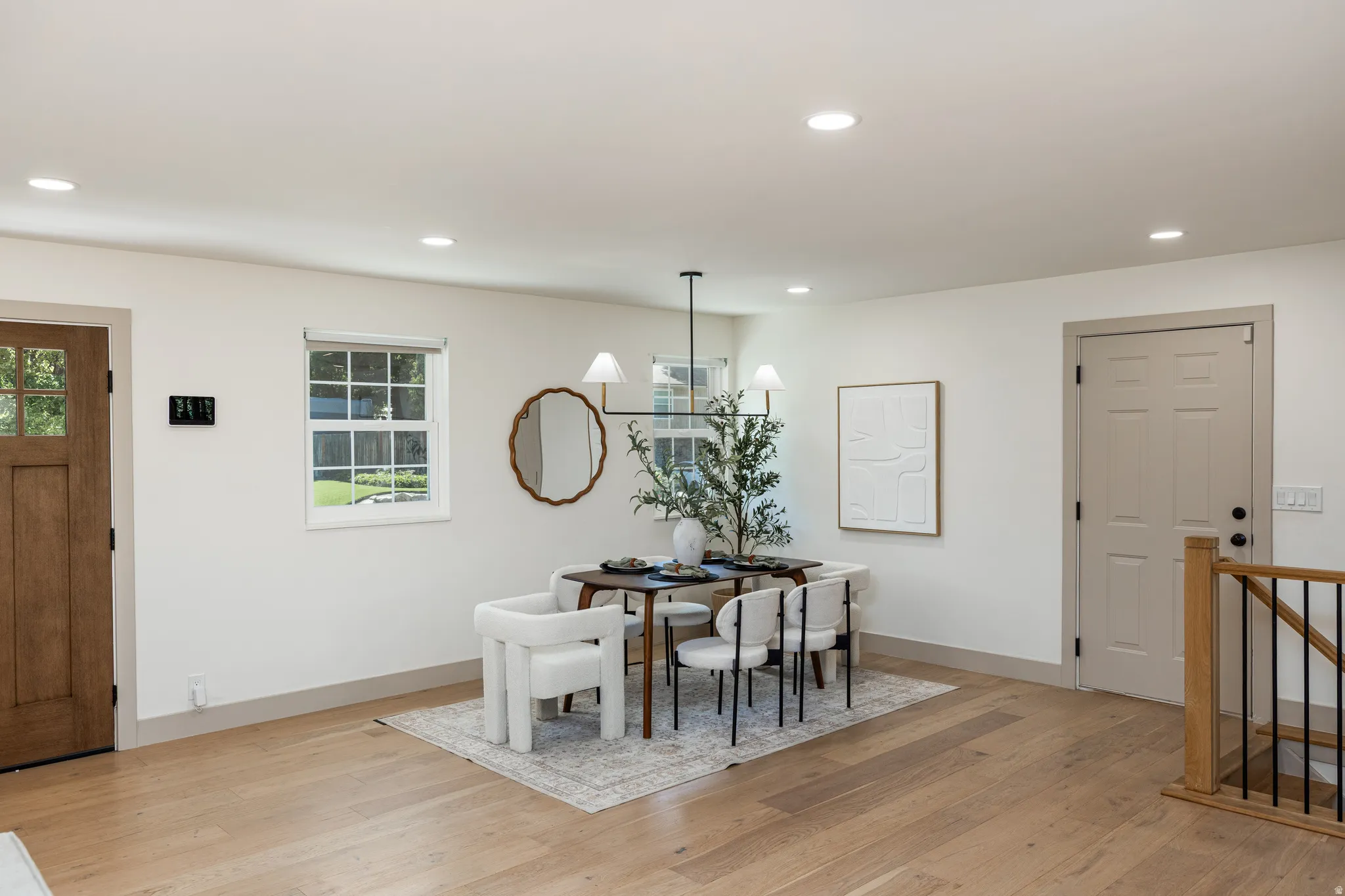 Spacious room featuring light wood-finish flooring, recessed lighting, and a modern chandelier