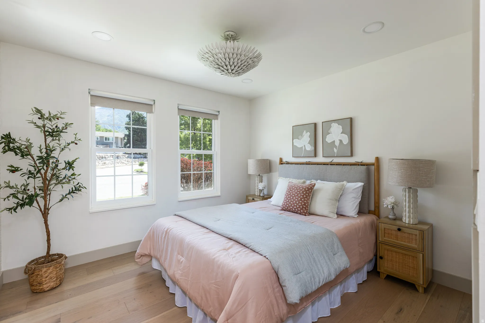 Bedroom featuring two double-hung windows, wood-finish flooring, a contemporary ceiling light fixture, recessed lighting, and light-toned wall paint