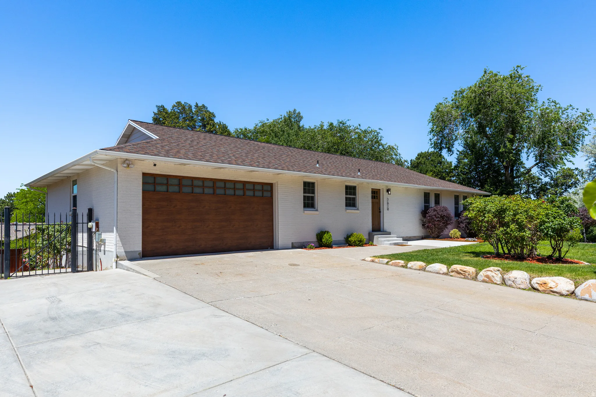 White exterior featuring a wood-finish garage door with upper-level windows