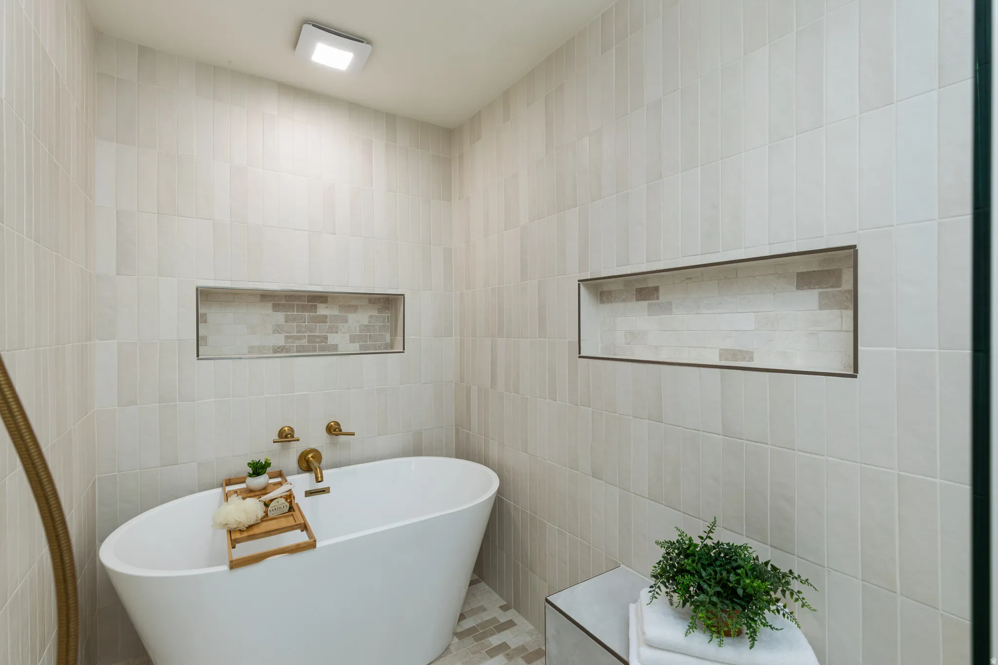 Freestanding soaking tub with gold-tone fixtures